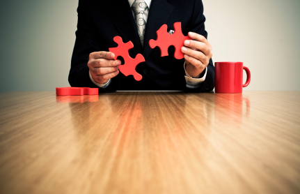 Businessman putting together jigsaw puzzle